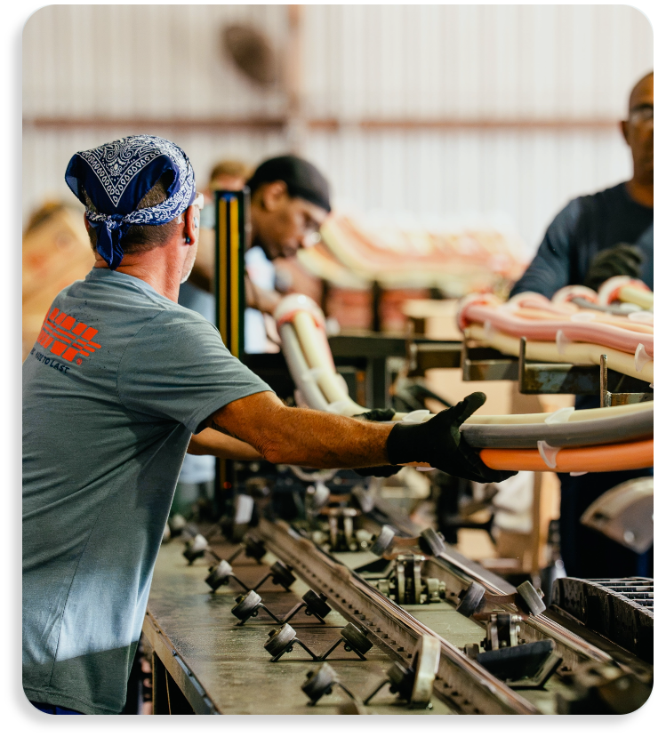 Worker assembling proprietary Opti-Com Multi-Duct and Micro-Duct conduit systems inside OMNI manufacturing facility.