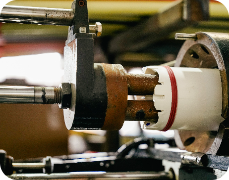 Automated industrial manufacturing components aligning a technical white multi-duct conduit jacket.
