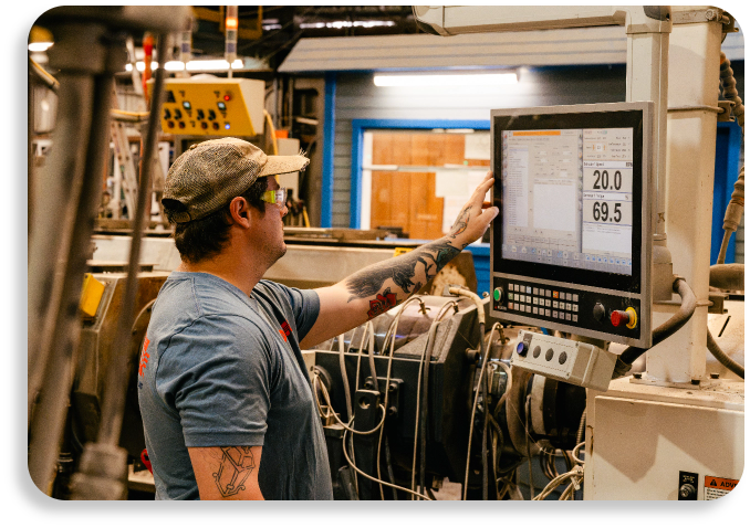An industrial plant operator tracking production parameters on a digital machine control panel monitor.